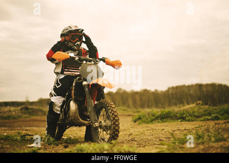 Caucasian man riding dirt bike in field Stock Photo
