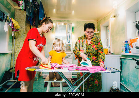 Caucasian women ironing laundry Stock Photo