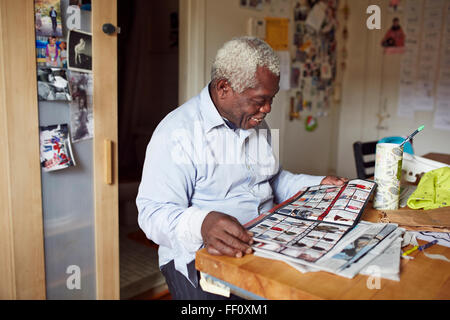 Black man reading magazine at table Stock Photo