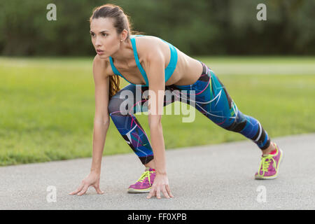 Mixed race woman stretching on road Stock Photo