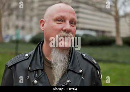 Middle aged Caucasian man sporting leather jacket and gray beard - USA Stock Photo