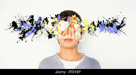Mixed race boy with paint splatter over face Stock Photo