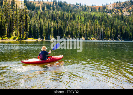 Caucasian man rowing canoe on remote lake Stock Photo