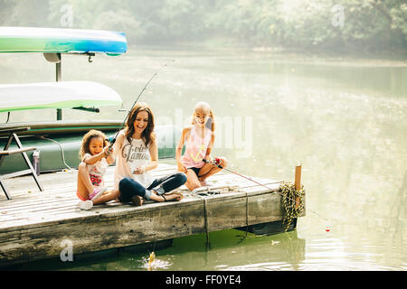Mother and daughters fishing in lake Stock Photo