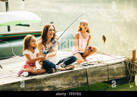 Mother and daughters fishing in lake Stock Photo