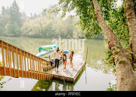 Family standing on dock in lake Stock Photo