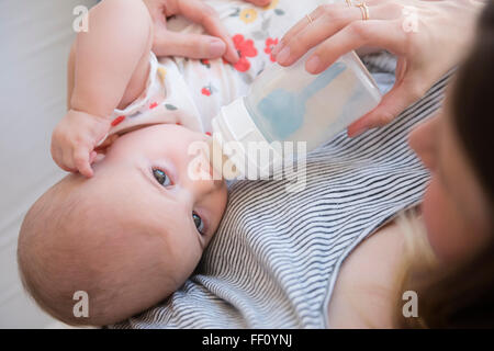 Caucasian mother feeding baby daughter Stock Photo