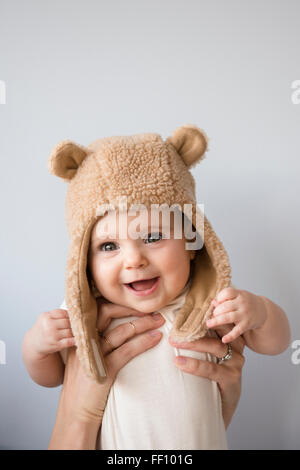 Caucasian mother holding baby daughter in fuzzy hat Stock Photo