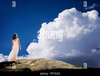 Mixed race woman standing on mountaintop Stock Photo