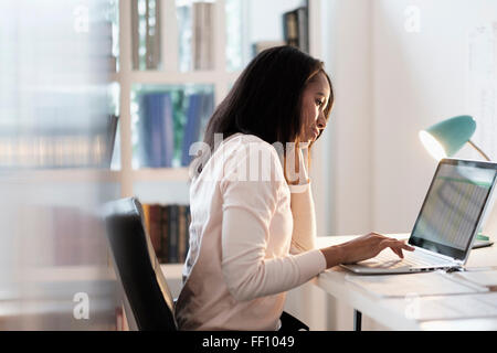 Mixed race businesswoman using laptop Stock Photo