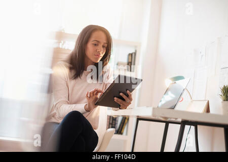 Mixed race businesswoman using digital tablet Stock Photo