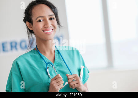 Mixed race nurse smiling in hospital Stock Photo