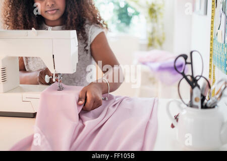 Black woman using sewing machine Stock Photo