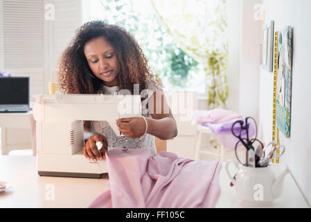 Black woman using sewing machine Stock Photo