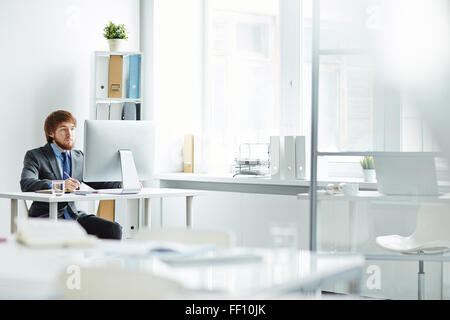 Handsome office worker working by computer Stock Photo