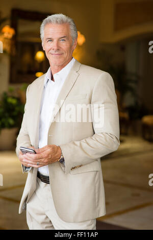 Older Caucasian man using cell phone outdoors Stock Photo