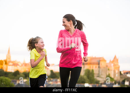 Caucasian mother and daughter jogging outdoors