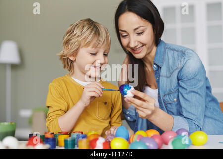 Mother and son painting eggs before Easter Stock Photo