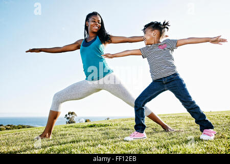 Black mother and daughter practicing yoga Stock Photo