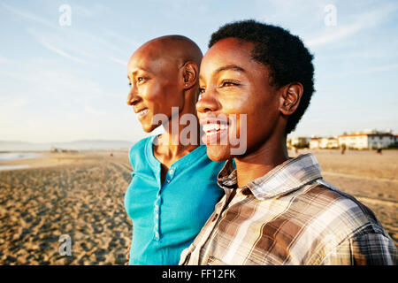 Black women smiling on beach Stock Photo