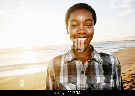 Black woman smiling on beach Stock Photo