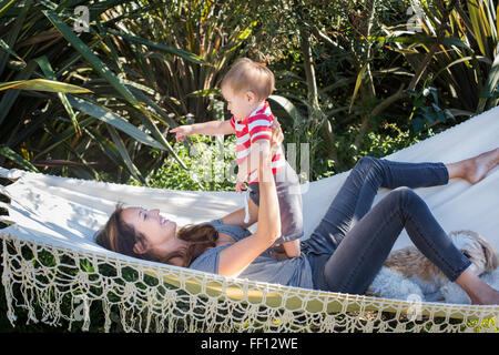 Mixed race mother holding baby in hammock Stock Photo