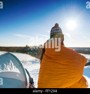 Hiker standing at snowy campsite Stock Photo