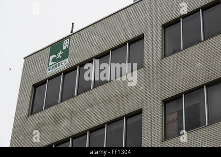 A multi-language tsunami evacuation sign on new building built behind the new 1.61 km long tsunami barrier in Kesennuma city on February 9, 2016, Miyagi Prefecture, Japan. 5 years after the 2011 Tohoku earthquake and tsunami the rebuilding project still goes on in Kesennuma. The controversial sea wall is designed to protect the fishing town that lost over 1000 lives in the disaster, although many locals complain that it is an eyesore and an unnecessary project given that new residences are being built on higher ground. © Rodrigo Reyes Marin/AFLO/Alamy Live News Stock Photo