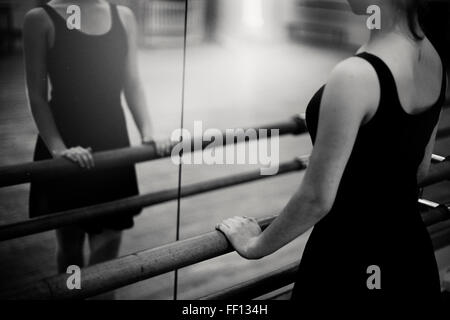 Caucasian ballerina standing at barre Stock Photo