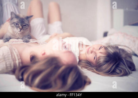 Caucasian girls laying on bed Stock Photo