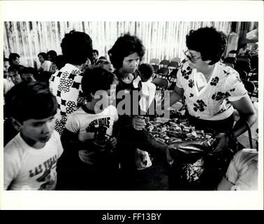 1980 - OPA Locka: Adult and Young Cuban refugees crowd around a volunteer as she distributes candy to the people waiting to be processed at the Opa Locka Center in the Miami area. © Keystone Pictures USA/ZUMAPRESS.com/Alamy Live News Stock Photo