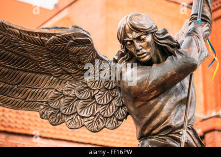 Close Up Detail Of Statue Of Archangel Michael With Outstretched Wings, Thrusting Spear Into Dragon Before Catholic Church Of St Stock Photo