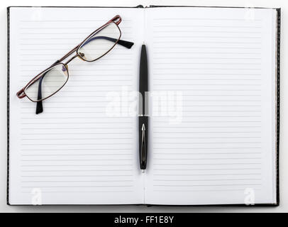 Open notebook with a pen and glasses Stock Photo
