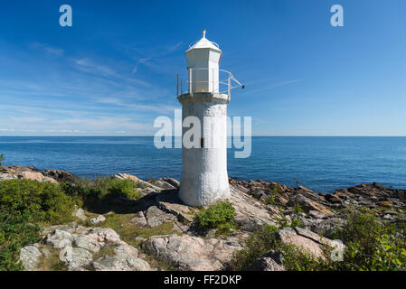 White lighthouse,blue sea and sky in bright sunlight at Stenshuvud National Park at the Baltic Sea coast in Skane, Sweden Stock Photo