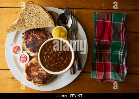 Fish cakes served in Nova Scotia, Canada. The dish is served with hickory beans, bread and piccalilliy. Stock Photo