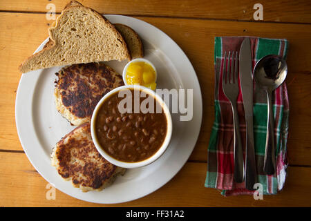 Fish cakes served in Nova Scotia, Canada. The dish is served with hickory beans, bread and piccalilliy. Stock Photo