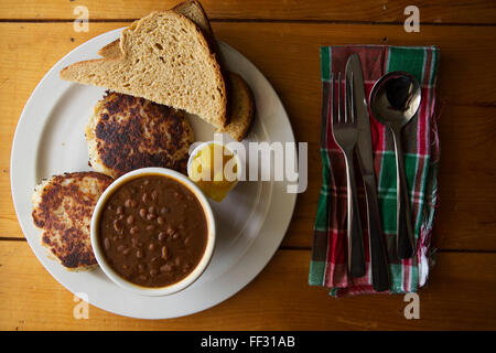 Fish cakes served in Nova Scotia, Canada. The dish is served with hickory beans, bread and piccalilliy. Stock Photo