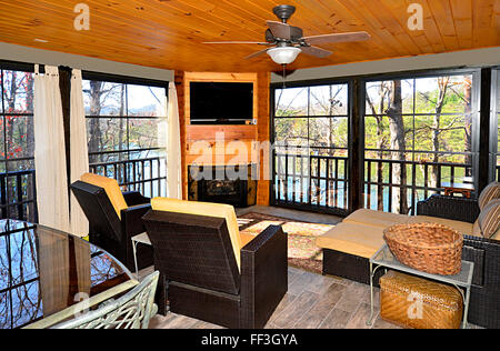 An enclosed porch area on a house overlooking a lake. Stock Photo
