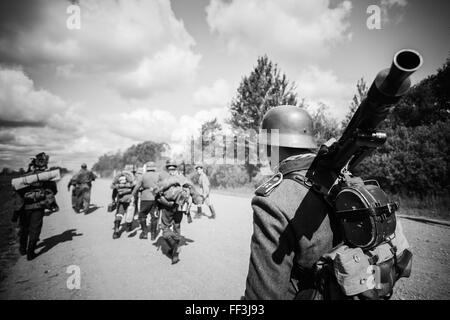 Unidentified re-enactors dressed as German soldiers during march in country road Stock Photo