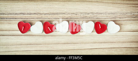 Picture of red and white heart candles on the wooden background. Valentine's Day. Symbol of love. Stock Photo
