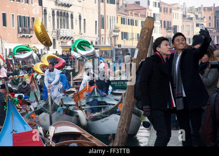 Tourists taking a sefie at the water parade  on the canal at the start of the 2016 Venice carnival, Cannaregio sestiere, Venice Stock Photo