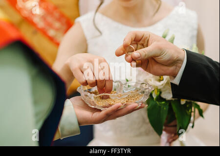 bride and groom are changing rings on their wedding Stock Photo