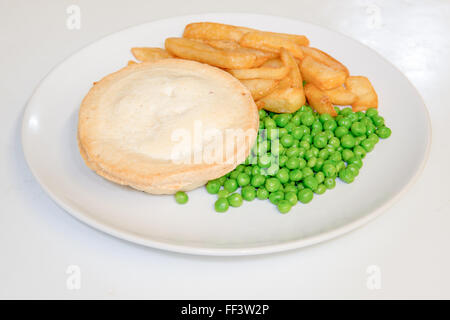 Pastry baked pie with chips and peas on a plate Stock Photo