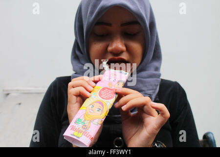 Sidoarjo, EAST JAVA, INDONESIA. 10th Feb, 2016. Indonesian muslim girl eat ''Say No To Valentine's Day'' chocolate at Sidoarjo, East Java, Indonesia, on February 10, 2016. Making chocolate themed ''Say No To Valentine's Day'' is intended as a form of rejection in the tradition of Valentine's Day celebrations in Indonesia. Valentine's Day celebrations in Indonesia controversy on a number of community organizations as judged according to Islamic law. © Suryanto/ZUMA Wire/Alamy Live News Stock Photo