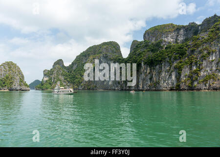 Boats sail on calm, emerald sea in Halong Bay, Vietnam Stock Photo