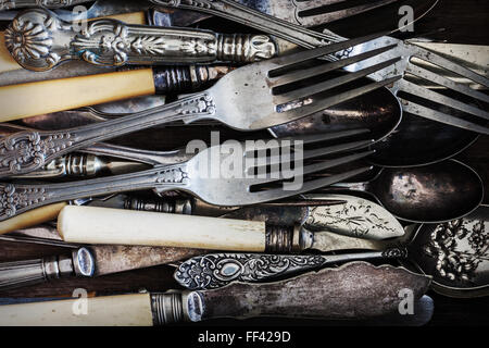 Vintage knives forks and spoons on an aged wood background Stock Photo
