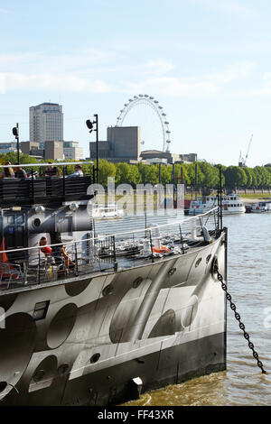 People on floating restaurant boat moored at Embankment on the River Thames in London, England. With London Eye in background Stock Photo