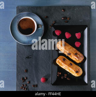 Coffe eclair with raspberries Stock Photo