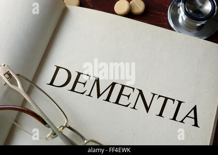 Book with diagnosis dementia and pills. Medical concept. Stock Photo