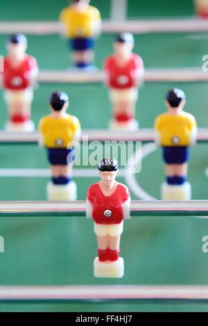 Closeup of the table football or foosball players in red and yellow jerseys. Stock Photo